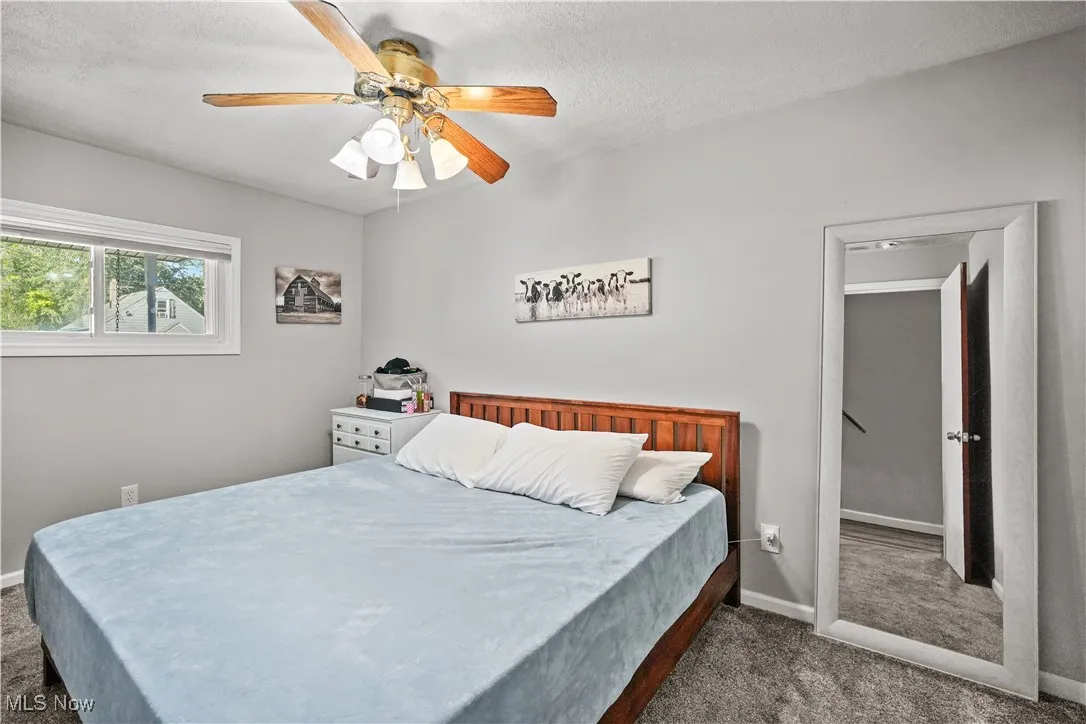 Bedroom featuring carpet floors, a textured ceiling, and a ceiling fan