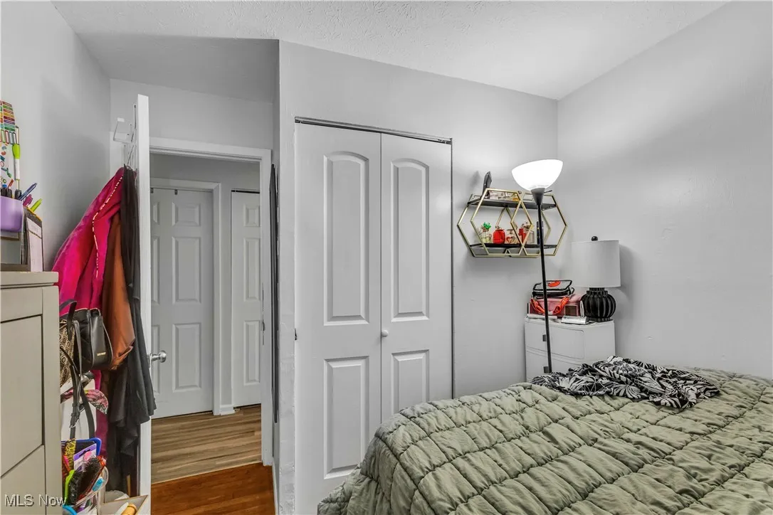 Bedroom with wood finished floors, a closet, and a textured ceiling