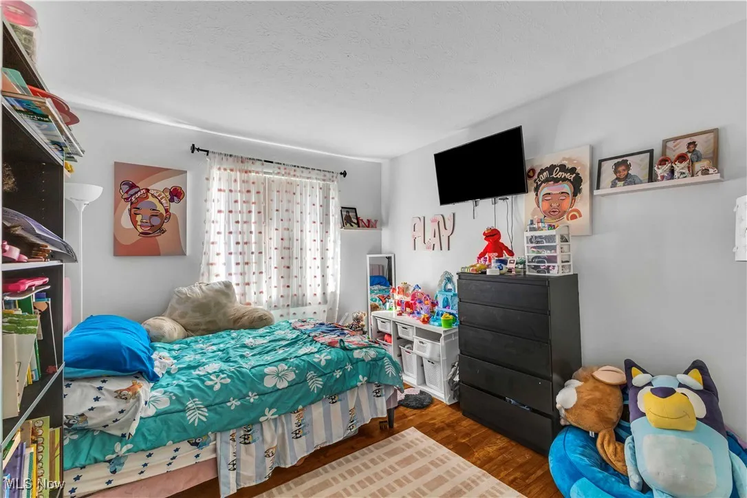 Bedroom with dark wood finished floors and a textured ceiling