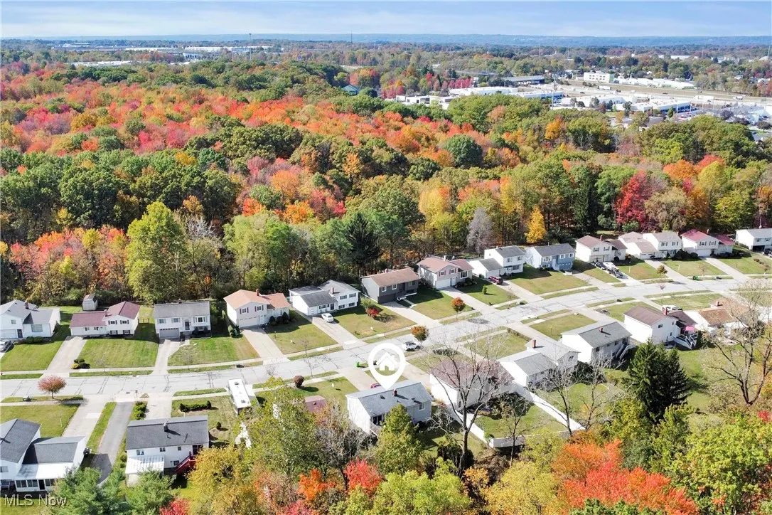 Aerial perspective of suburban area featuring a heavily wooded area
