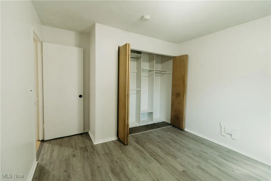 Unfurnished bedroom featuring wood finished floors and a closet