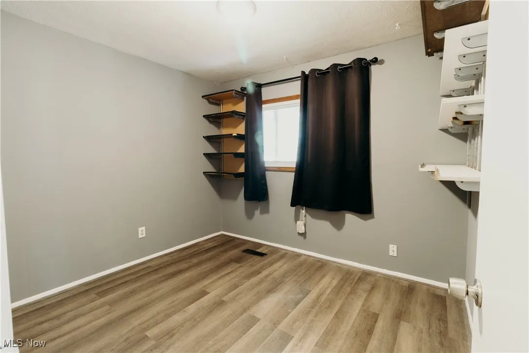Empty room featuring light wood finished floors and baseboards