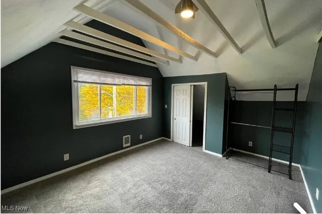 Unfurnished bedroom with light carpet and baseboards