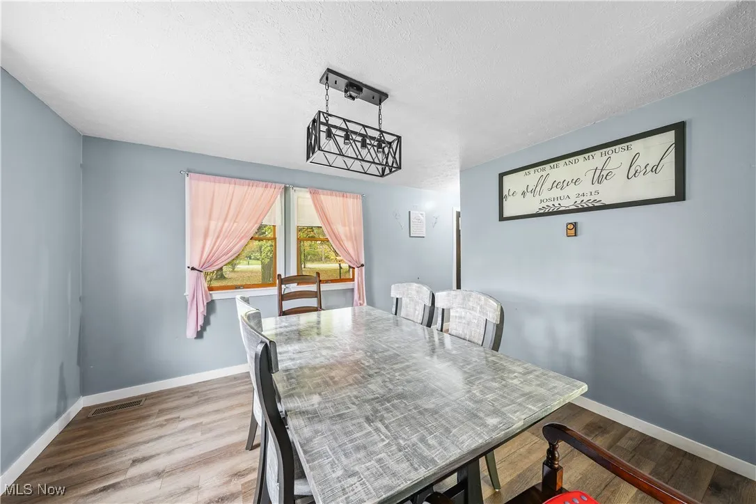 Dining space featuring wood finished floors and a textured ceiling