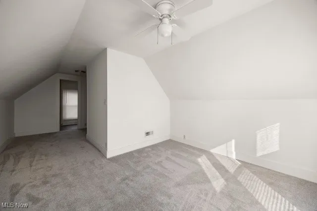 Bonus room featuring carpet, vaulted ceiling, and ceiling fan