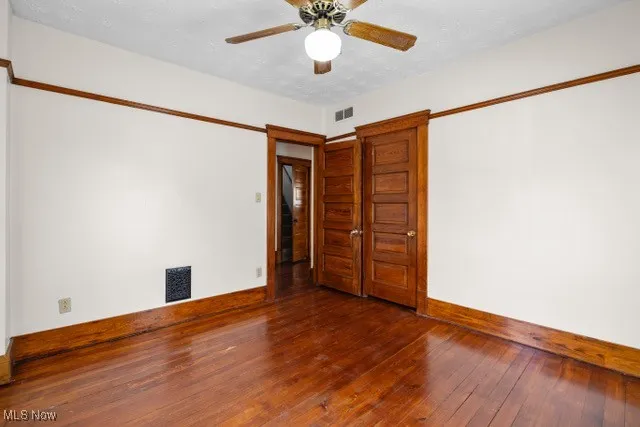 Empty room with hardwood / wood-style flooring and a ceiling fan