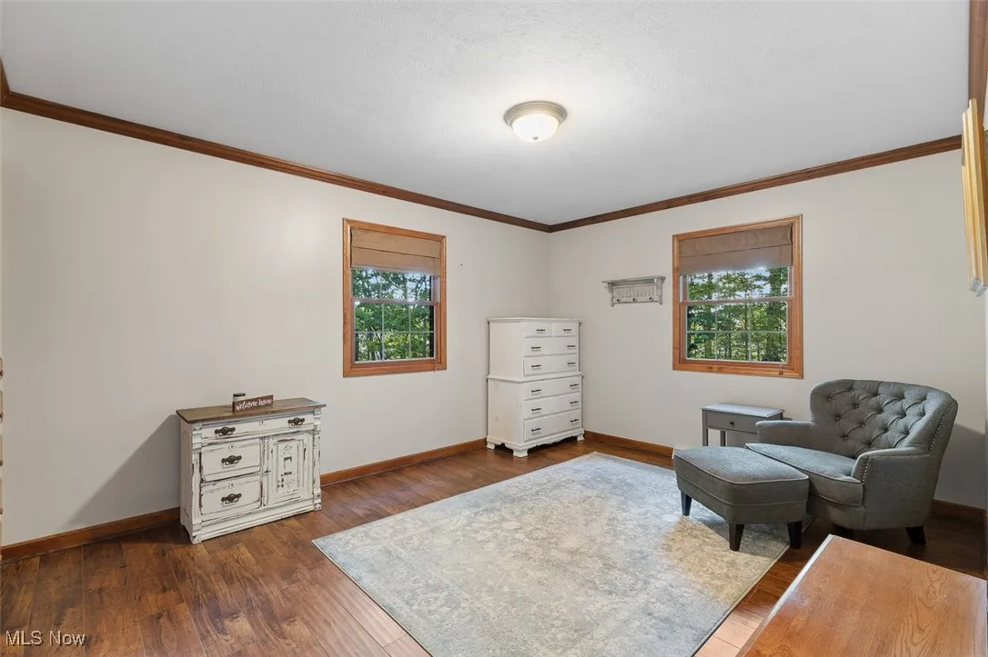 Bedroom with ornamental molding and dark wood finished floors