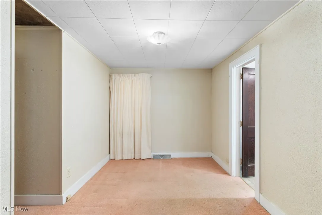 Carpeted empty room with baseboards