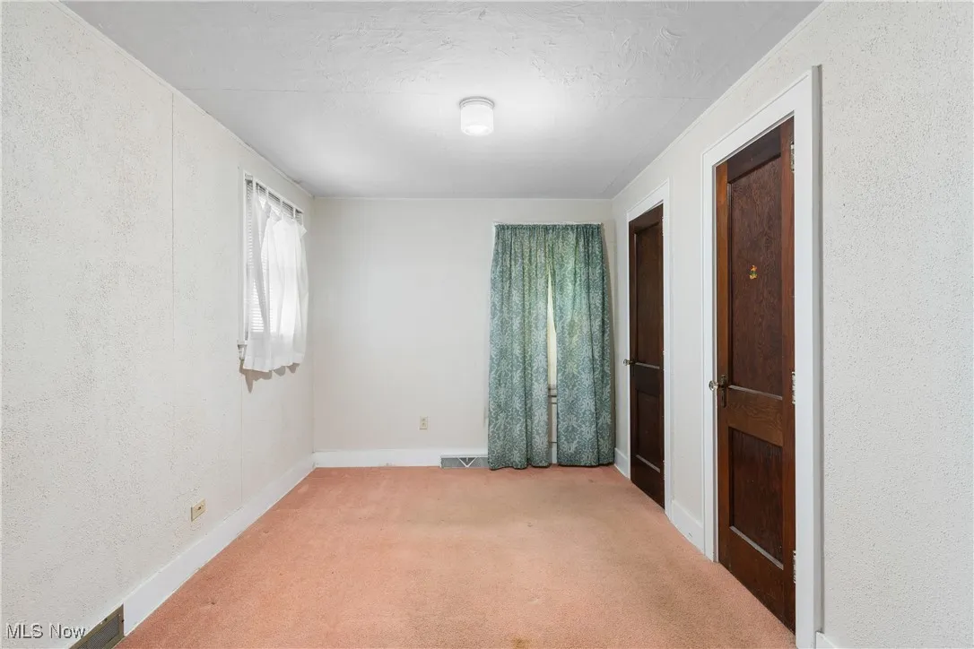 Unfurnished room with light carpet, a textured wall, and a textured ceiling