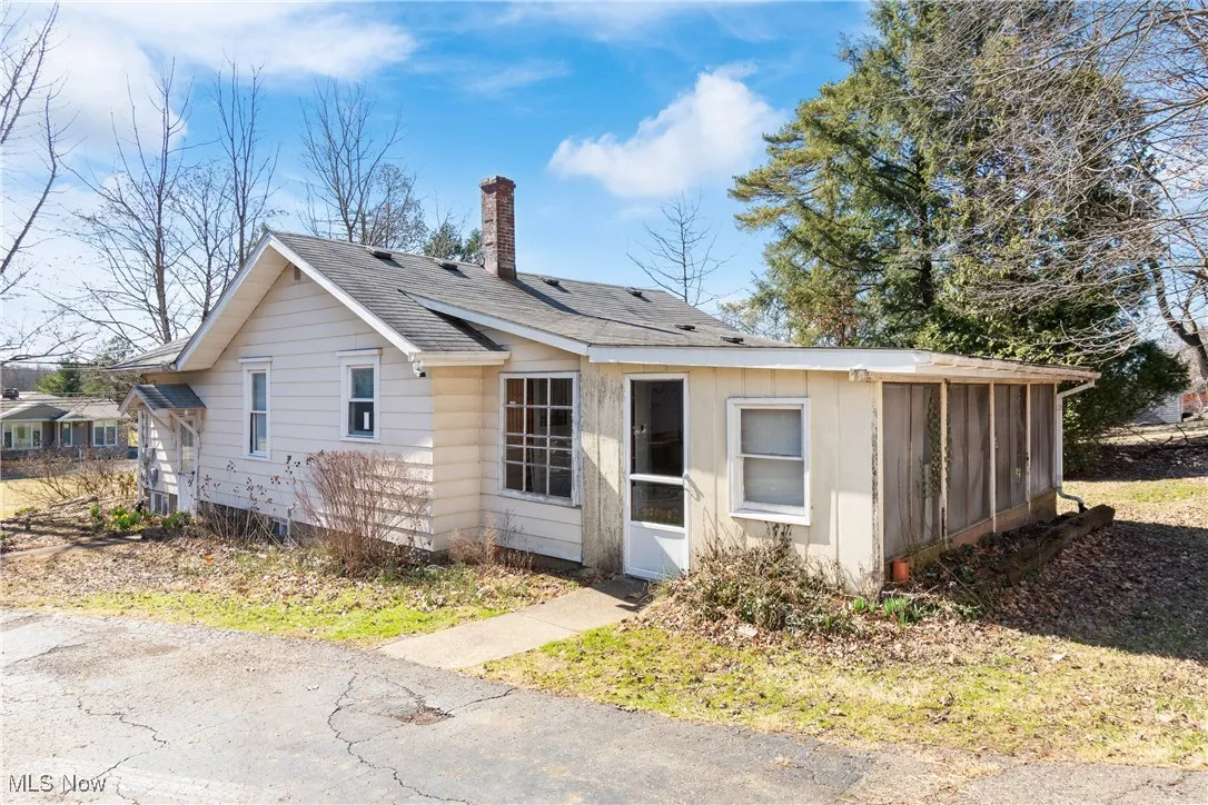 View of front of property featuring a chimney and roof with shingles