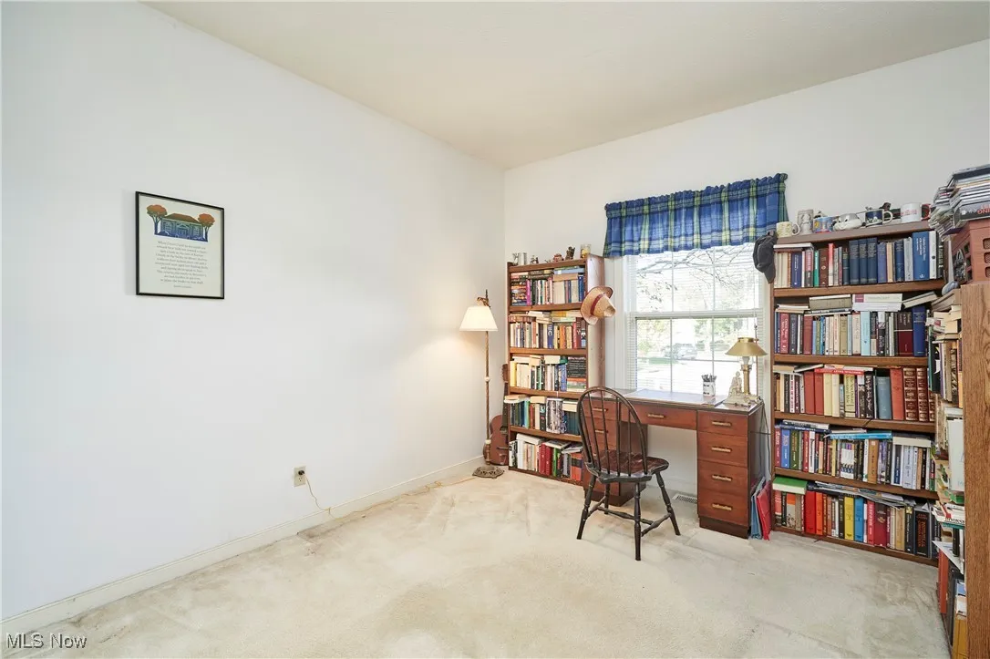 Home office with light colored carpet and baseboards