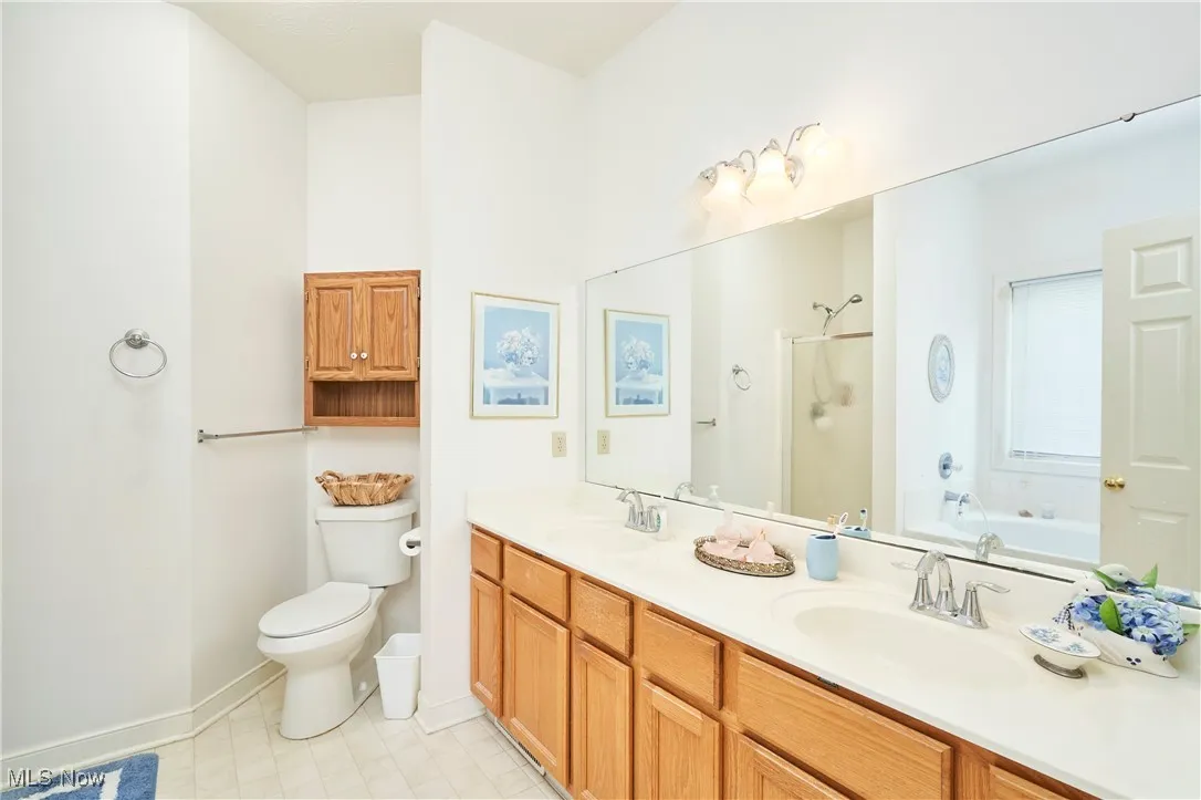 Bathroom featuring a stall shower, double vanity, and a bath
