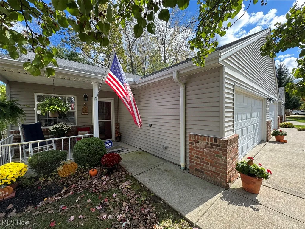View of front with vinyl siding, a 2 car garage, and a covered porch