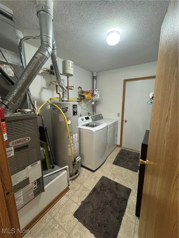 Utility room featuring washer and dryer, water heater, and gas furnace