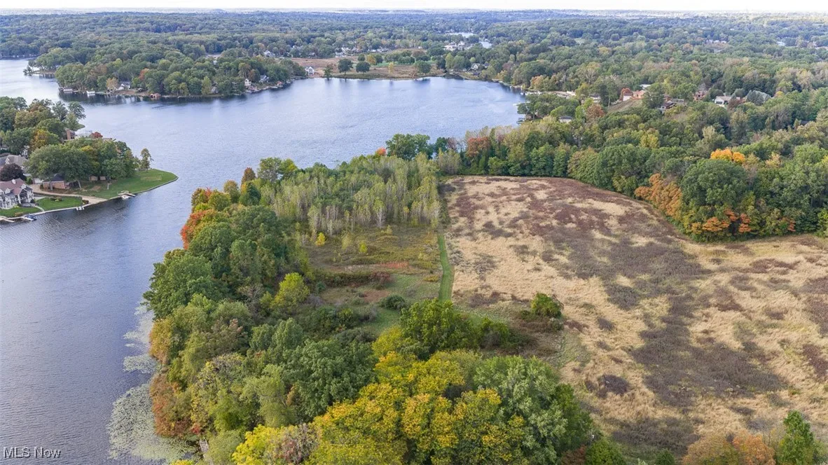 View of property location featuring a nearby body of water and a heavily wooded area