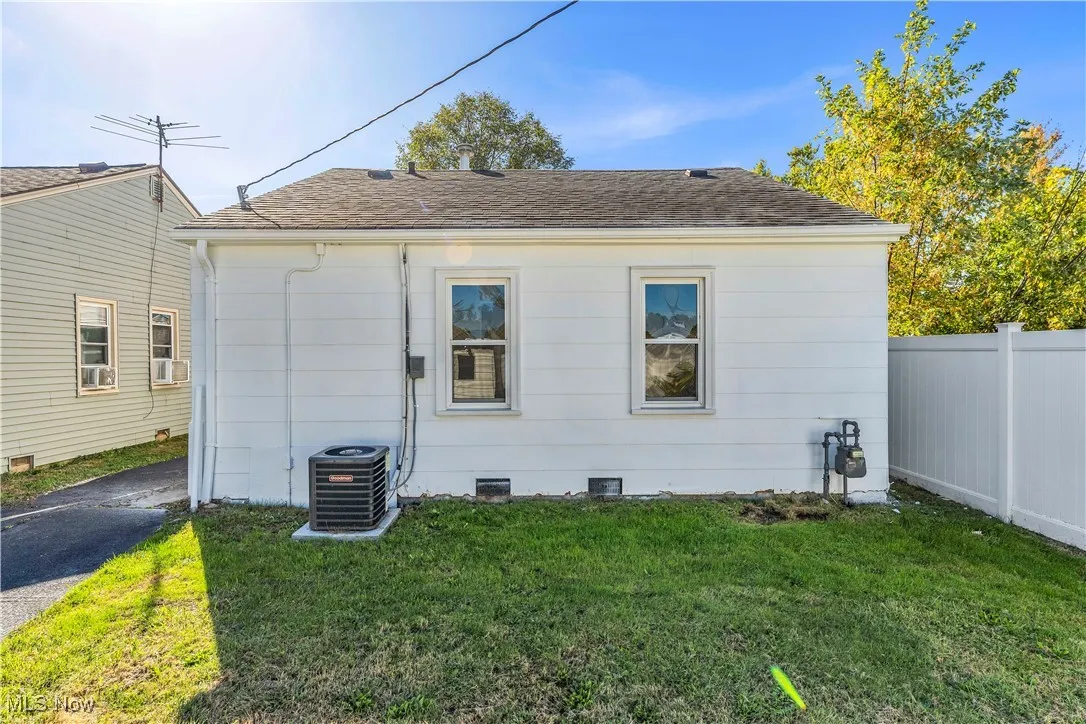 Back of property featuring a shingled roof and crawl space