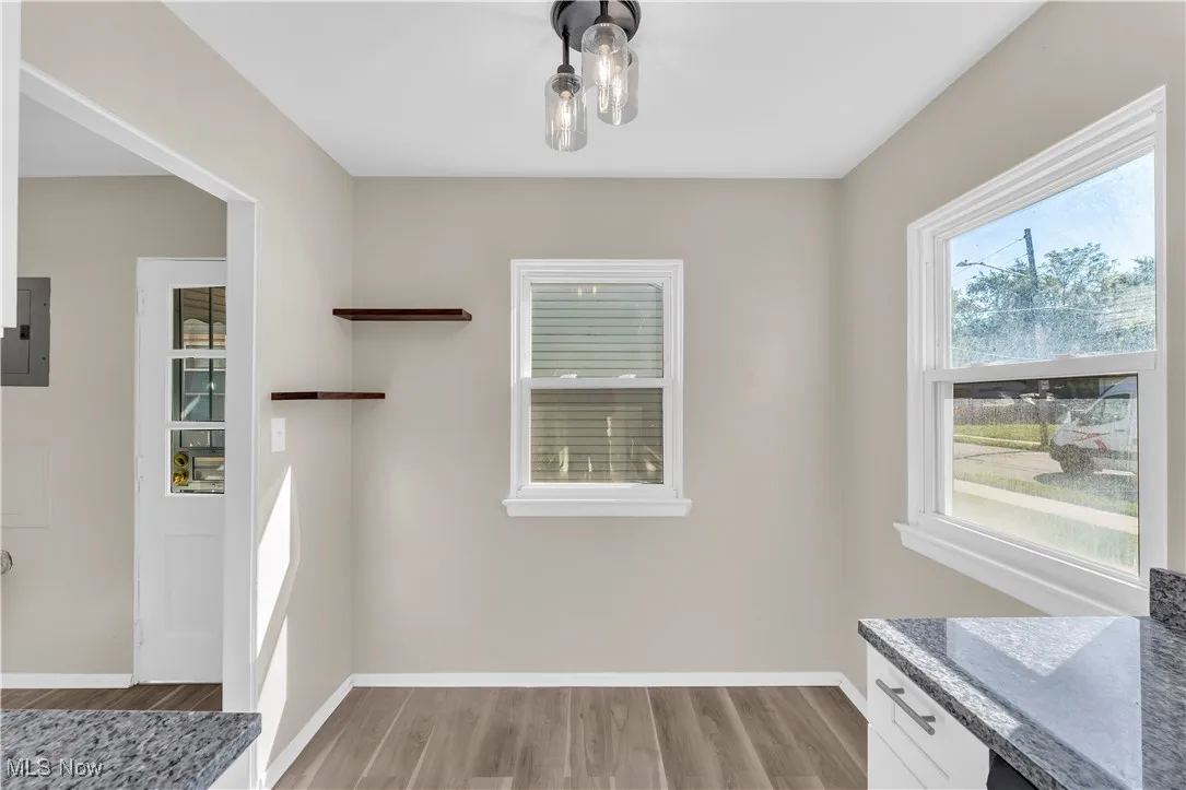 Unfurnished dining area with light wood-type flooring and electric panel