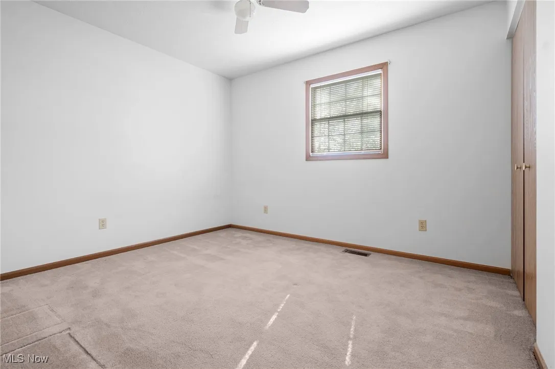 Spare room with light colored carpet and a ceiling fan