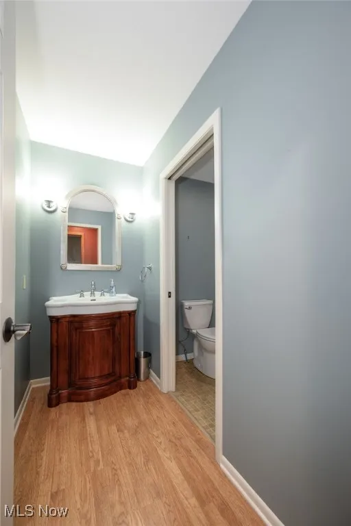 Half bathroom featuring light wood-style floors and vanity