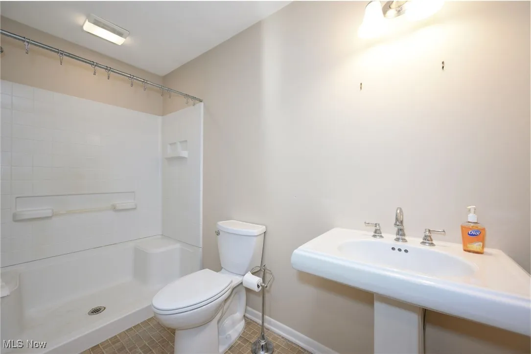 Bathroom with tile patterned flooring and a shower