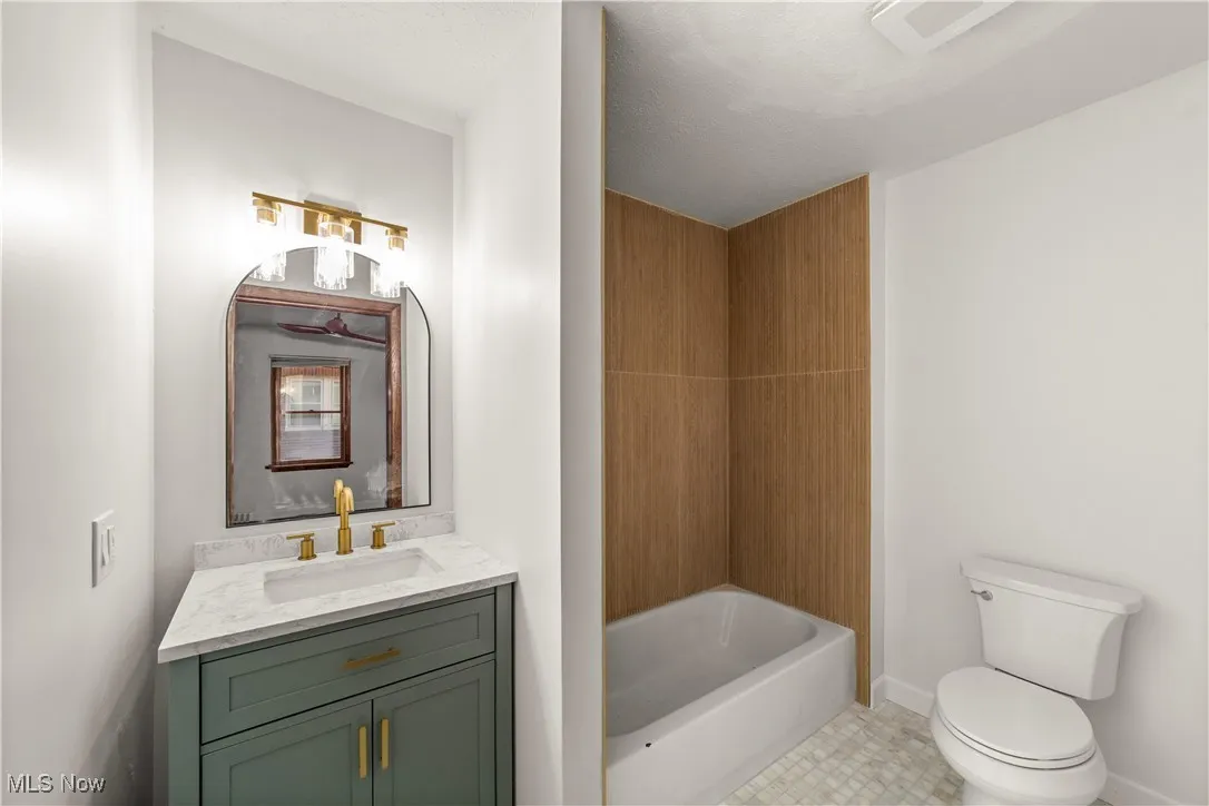 Full bath with vanity and light tile patterned floors