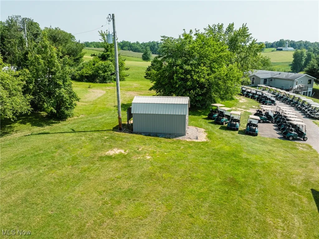 View of grassy yard featuring a view of rural / pastoral area and a storage shed