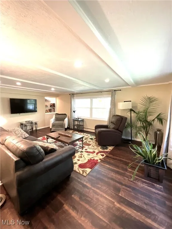 Living area featuring dark wood-type flooring, a baseboard heating unit, and recessed lighting