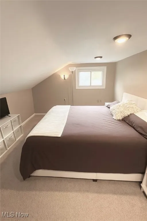 Bedroom with carpet and vaulted ceiling