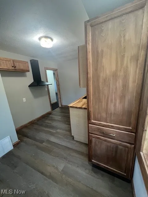 Kitchen featuring a textured ceiling, dark wood-type flooring, and light countertops