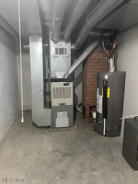 Utility room featuring water heater and heating unit