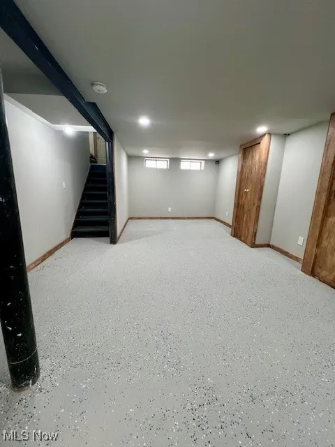 Below grade area with stairway and baseboards