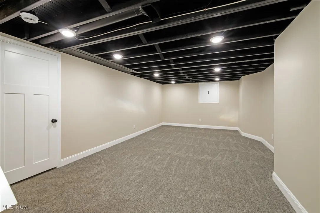 Finished below grade area with light colored carpet and baseboards