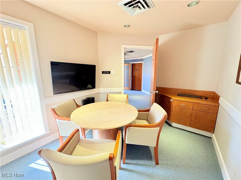 Consultation room with light colored carpet and recessed lighting