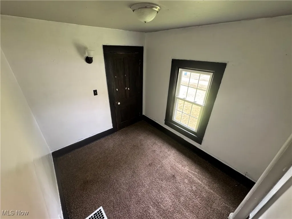 Carpeted empty room featuring baseboards