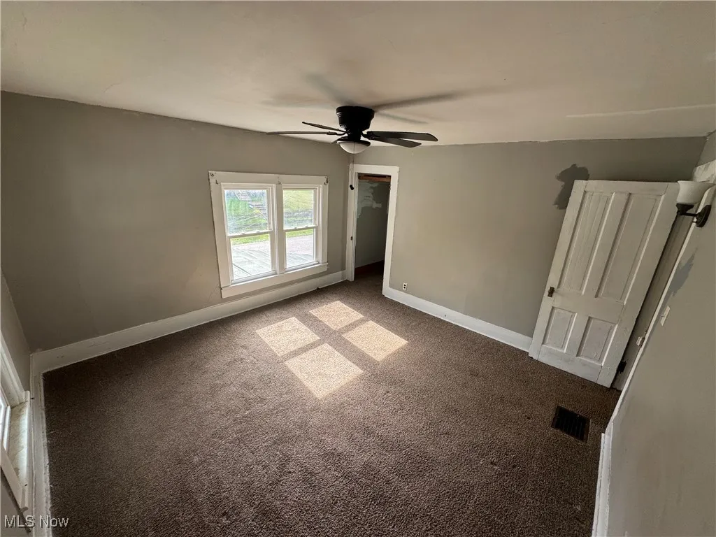 Unfurnished bedroom with carpet floors and a ceiling fan