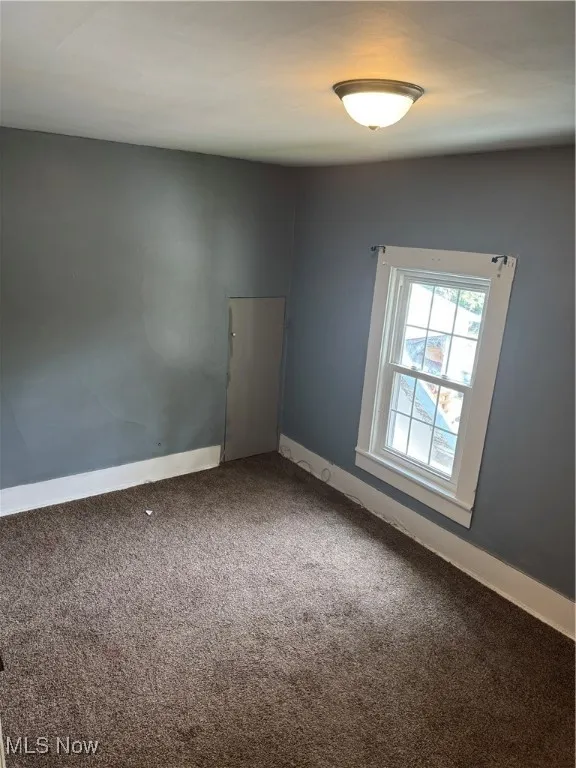 Carpeted empty room with baseboards
