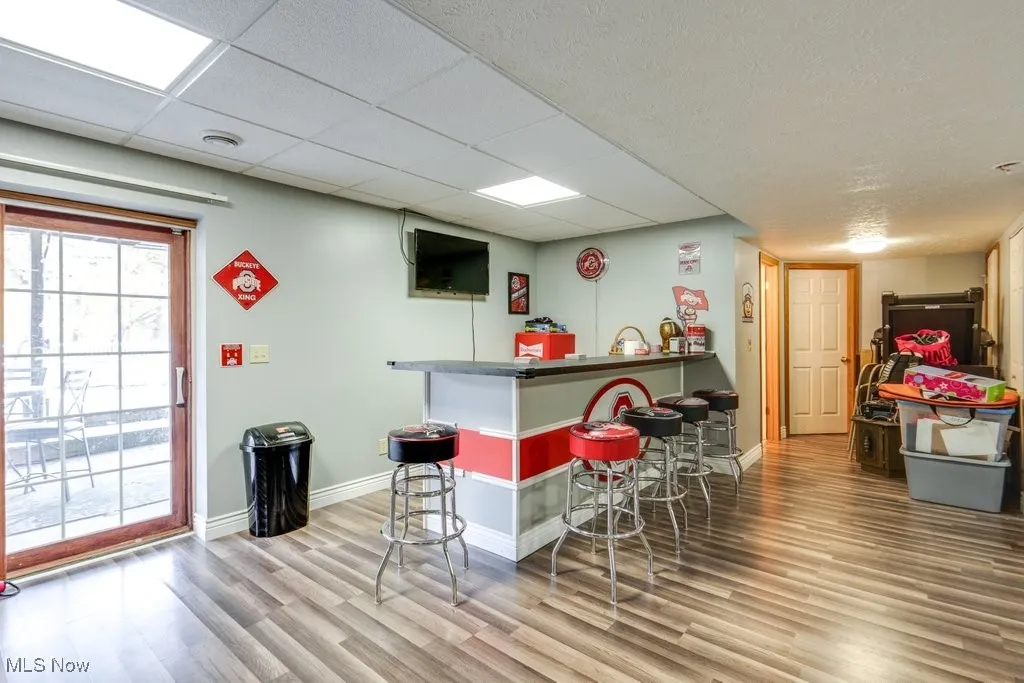 Indoor dry bar featuring dark countertops and a paneled ceiling