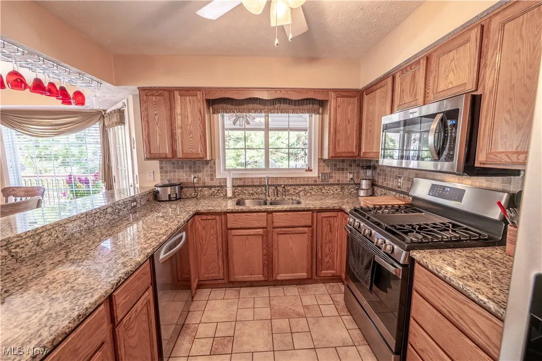 Kitchen with granite counters, SS appliances, and ceiling fan