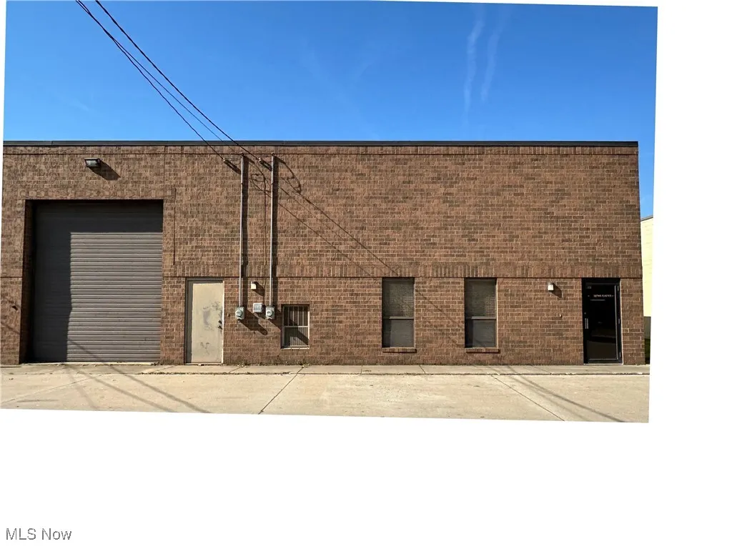 Front view of building with overhead garage door, man door and office entrance
