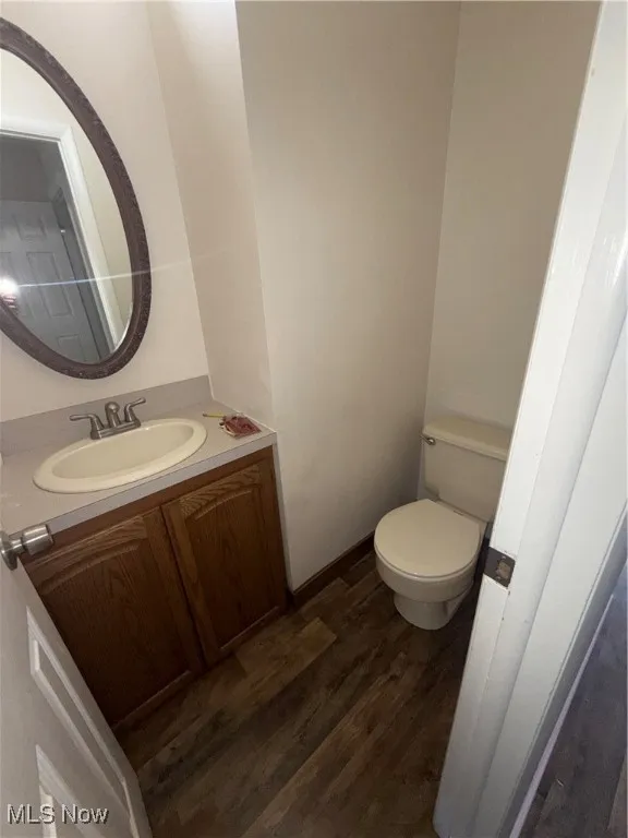 Half bath featuring dark wood finished floors and vanity