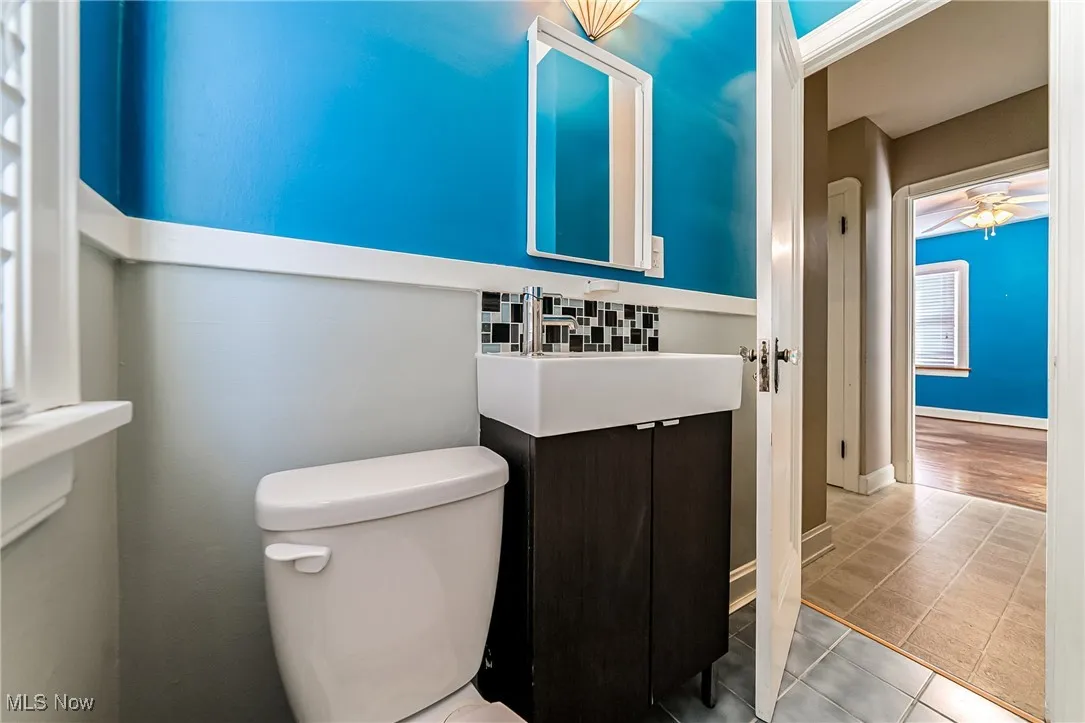 Bathroom featuring vanity, tile patterned floors, a ceiling fan, and backsplash