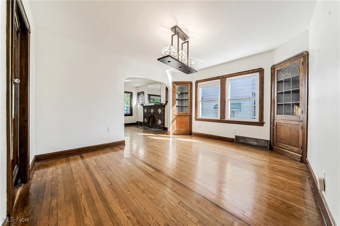 Unfurnished dining area with light wood-style floors and arched walkways