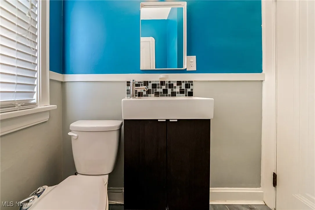 Half bathroom featuring vanity and toilet