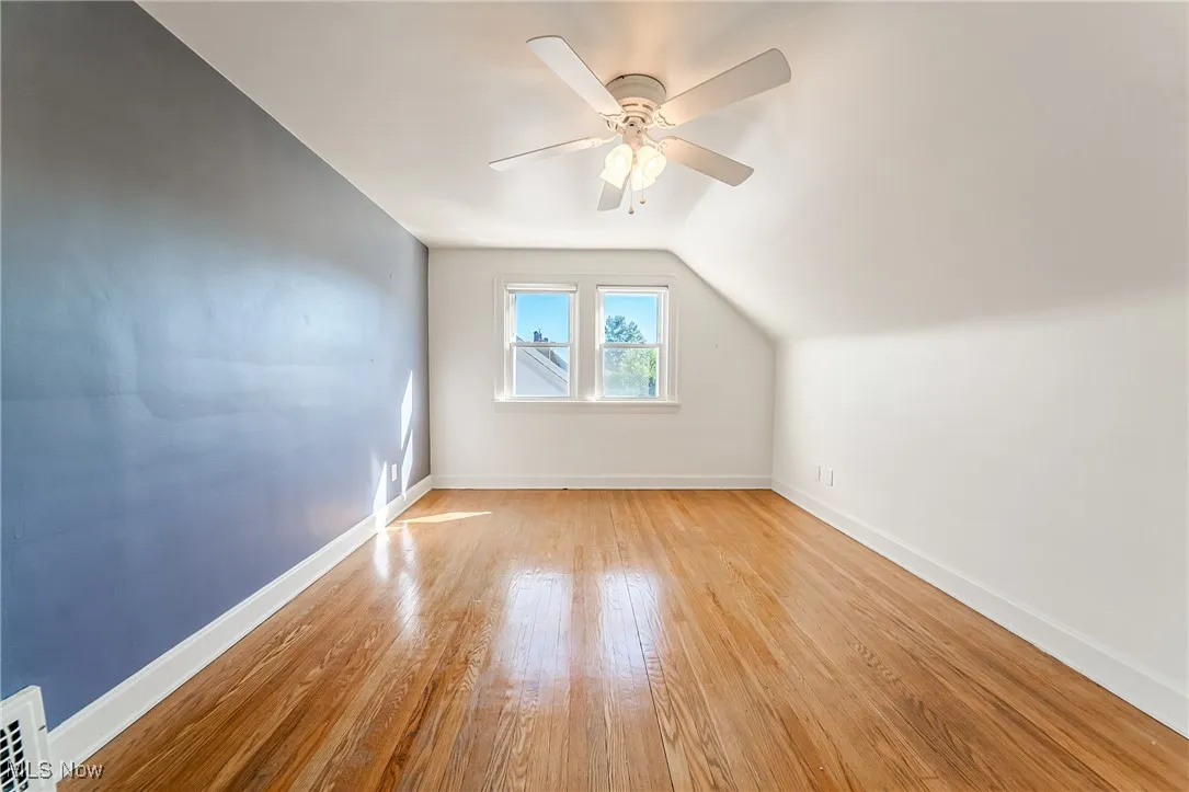 Additional living space with light wood-type flooring, vaulted ceiling, and ceiling fan
