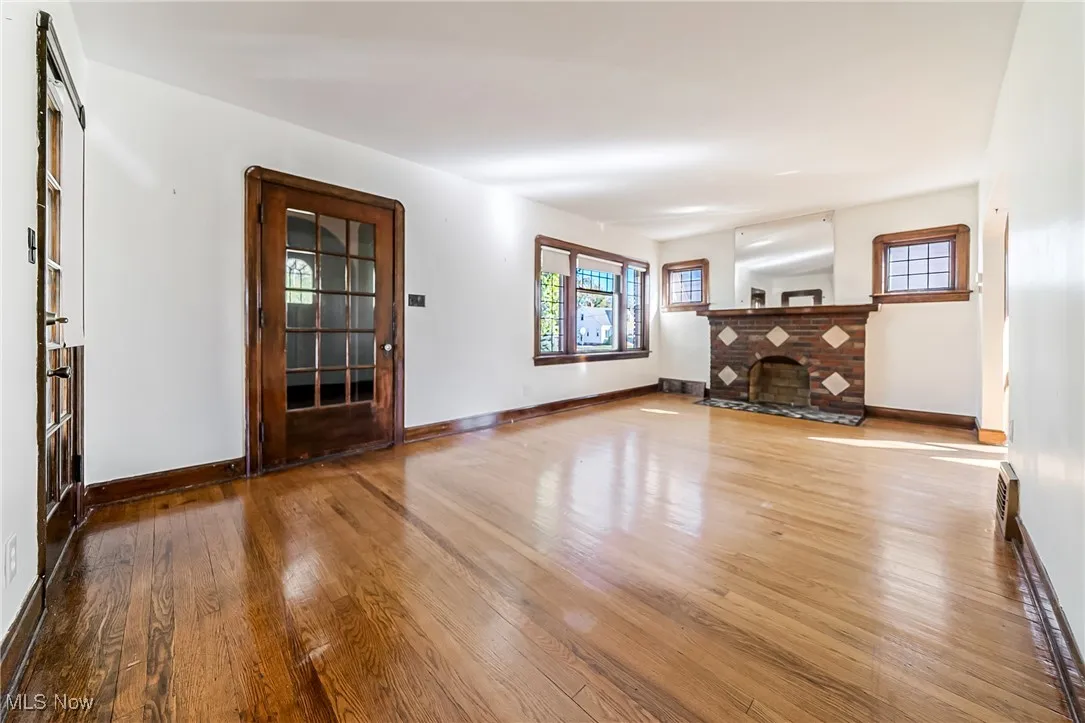 Unfurnished living room with hardwood / wood-style flooring and a fireplace
