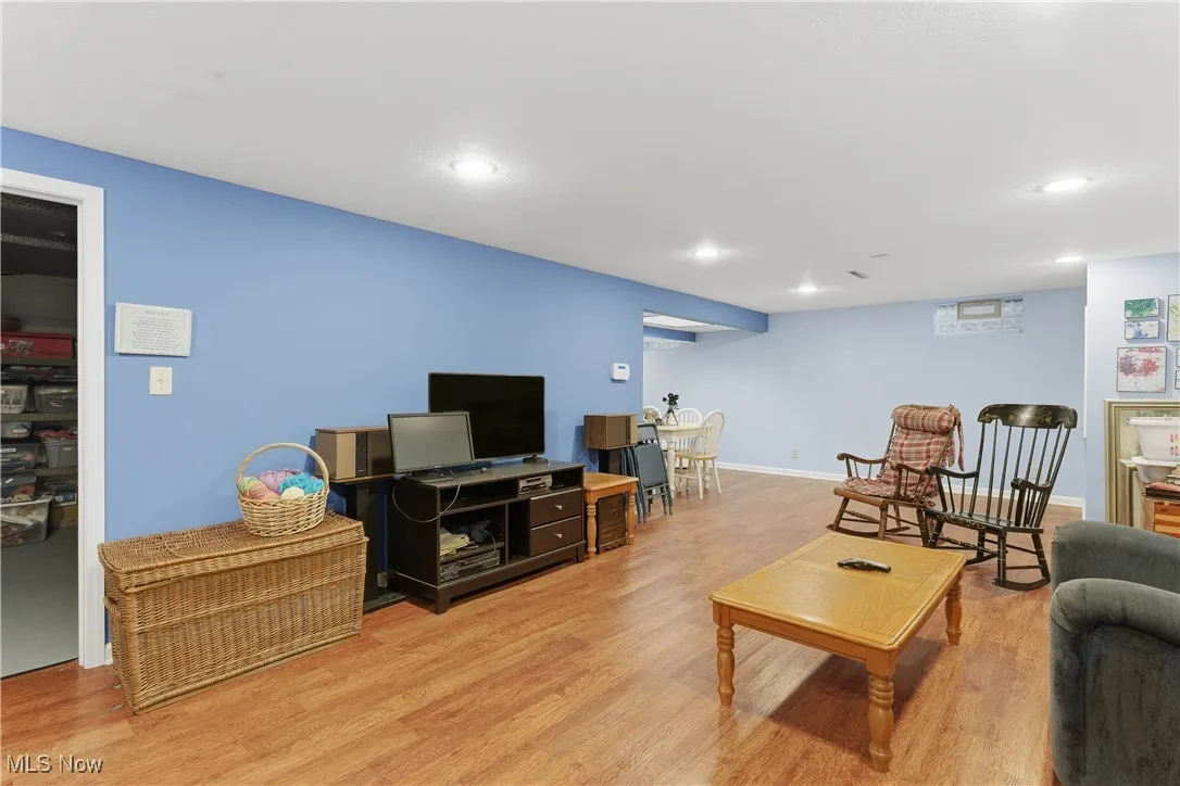 Living room with light wood-style flooring and recessed lighting