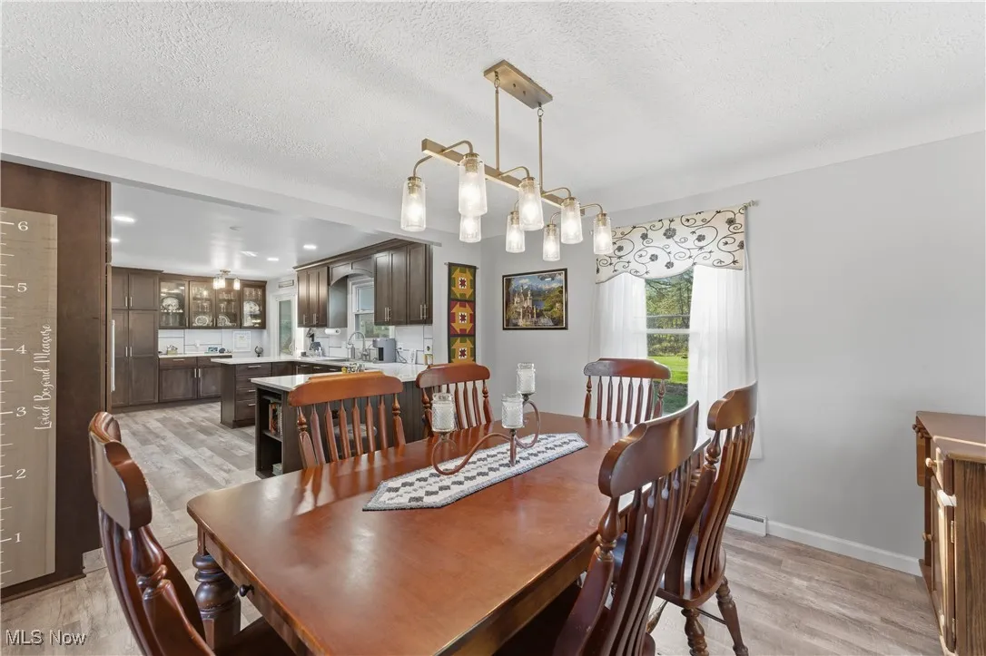 Dining room featuring a textured ceiling, light wood-type flooring, and recessed lighting
