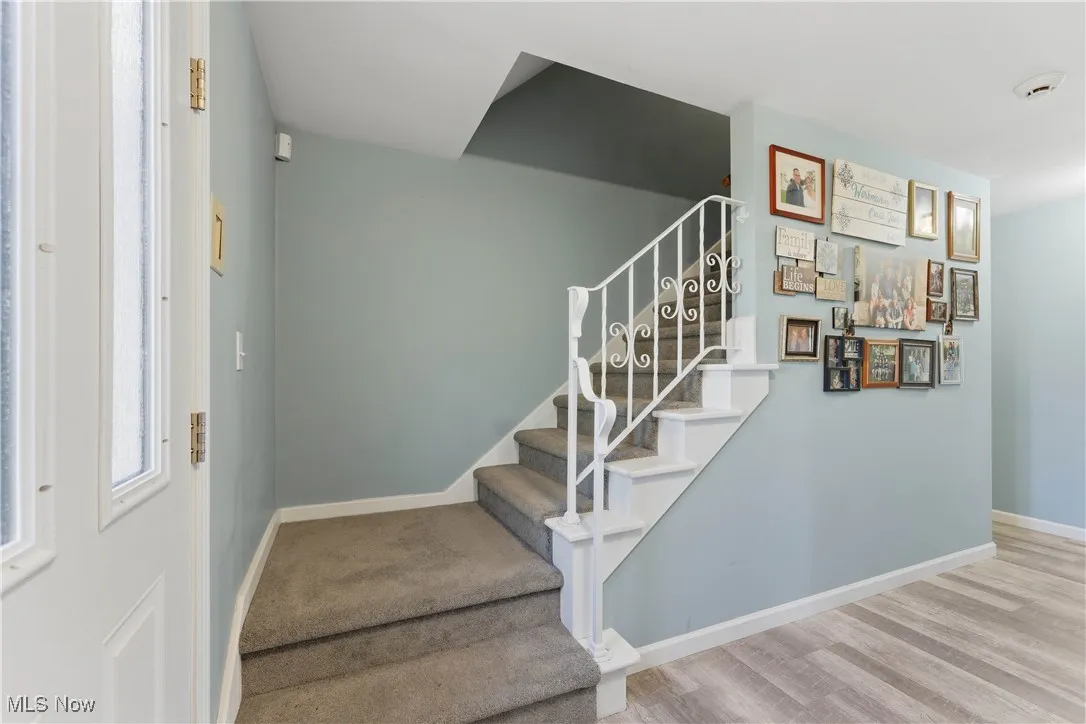 Staircase with baseboards and wood finished floors