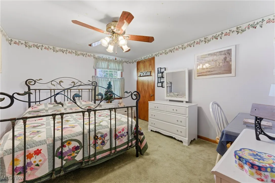 Bedroom featuring light colored carpet and ceiling fan