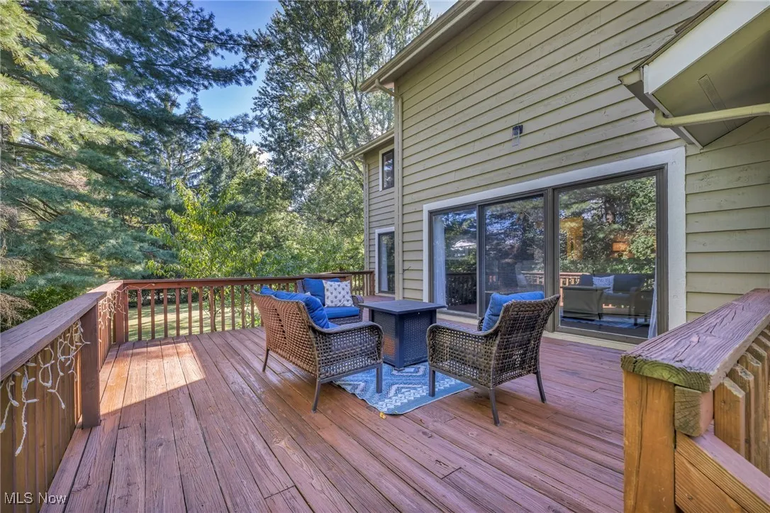 Wooden deck with an outdoor living space and view of wooded area
